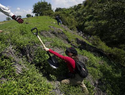 Los voluntarios usan palas mientras buscan en un área los cuerpos de personas desaparecidas en las afueras de Cuautla, México, el martes 12 de octubre de 2021. (AP Foto/Fernando Llano)