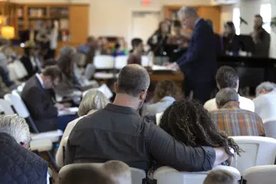 Una pareja reza durante una misa de Domingo de Ramos en la Iglesia Parroquial Presbiteriana, donde recordaron a las víctimas del tiroteo de hace unos días en una escuela de Nashville, el domingo 2 de abril de 2023 en Franklin, Tennessee. (AP Foto/Wade Payne)