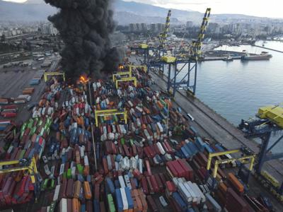 Smoke rises from burning containers at the port in the earthquake-stricken town of Iskenderun, southern Turkey, Tuesday, Feb. 7, 2023. Television images on Tuesday showed thick black smoke rising from burning containers at Iskenderun Port. Reports said the fire was caused by containers that toppled over during the powerful earthquake that struck southeast Turkey on Monday. Turkey's state-run Anadolu Agency said a Turkish Coast Guard vessel was assisting efforts to extinguish fire. (Serdar Ozsoy/Depo Photos via AP)