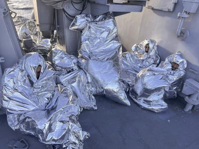 En esta foto proporcionada por la Guardia Costera griega, algunos de los nueve hombres que sobrevivieron a un naufragio y fueron encontrados en un islote deshabitado están cubiertos con una manta térmica mientras se sientan a bordo de un barco de la Guardia Costera griega, en el Mar Egeo, Grecia, el martes 1 de noviembre de 2022. Una importante operación de búsqueda y rescate estaba en marcha el martes para decenas de personas desaparecidas después de que el bote en el que viajaban volcó y se hundió en un clima tormentoso durante la noche frente a la costa de una isla cerca de la capital griega. La guardia costera dijo que nueve sobrevivientes, todos hombres, habían sido encontrados en un islote deshabitado al sur de la isla de Evia y habían sido recogidos por un barco de la guardia costera. (Guardia Costera griega vía AP)