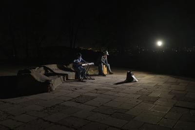 Músicos callejeros tocan instrumentos en una plaza sin luz eléctrica en Kiev, Ucrania, el martes 18 de octubre de 2022. (AP Foto/Emilio Morenatti)