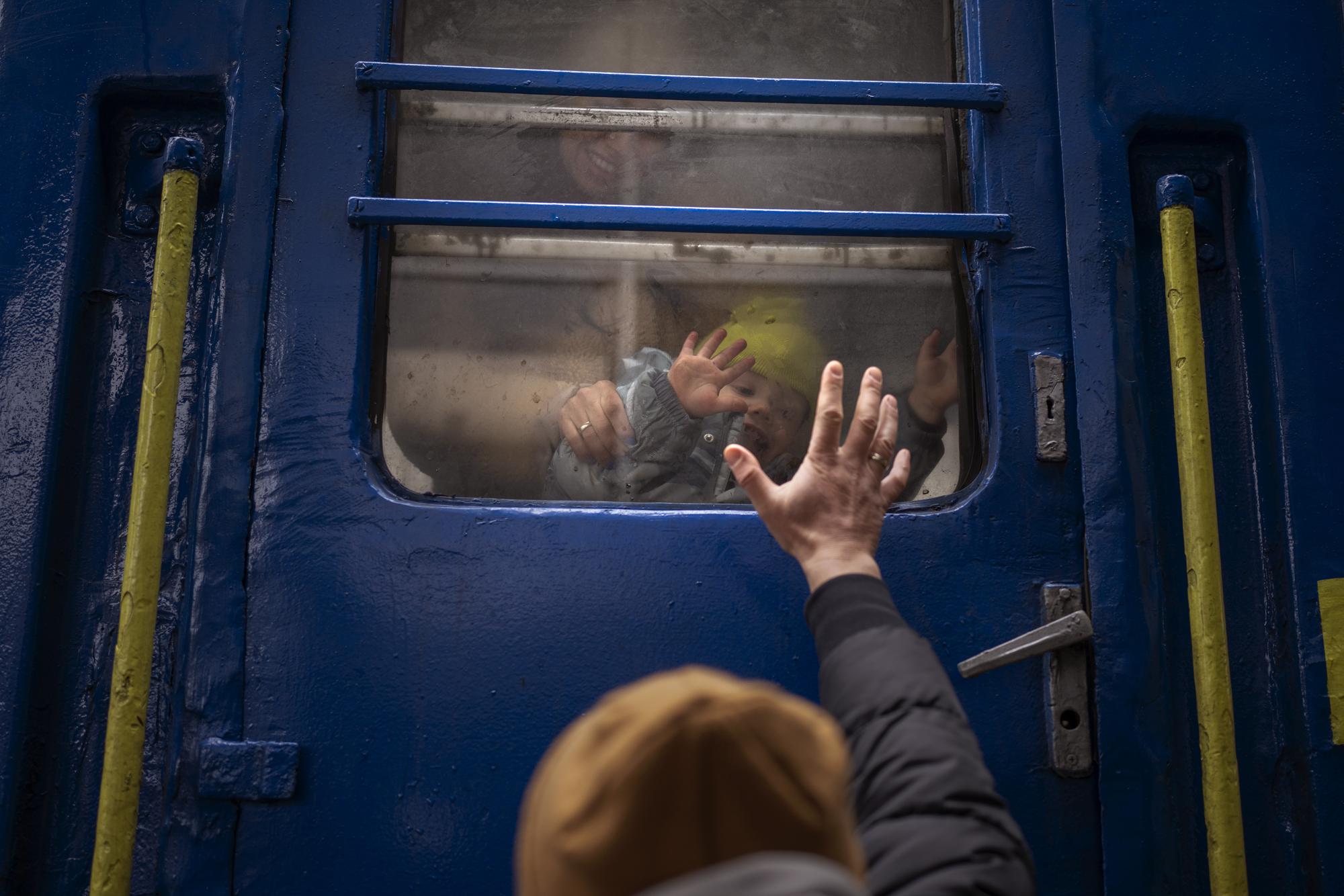 Stanislav, 40, says goodbye to his son David, 2, and his wife Anna, 35, on a train to Lviv at the Kyiv station, Ukraine, Thursday, March 3. 2022. Stanislav is staying to fight while his family is leaving the country to seek refuge in a neighbouring country. (AP Photo/Emilio Morenatti)