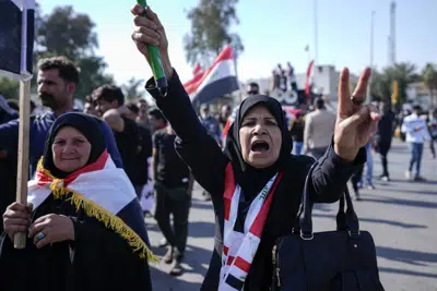 Manifestantes ondean banderas de Irak durante una protesta contra un proyecto de ley electoral, cerca del Parlamento en Bagdad, el lunes 27 de febrero de 2023. (AP Foto/Hadi Mizban)