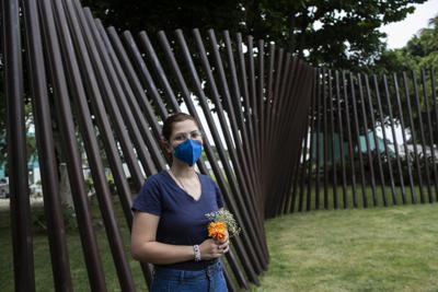 Bruna Chaves, una estudiante de química de 25 años que perdió a su madre por el COVID-19, posa para una fotografía en un cementerio, en Río de Janeiro, Brasil, el 27 de octubre de 2021. En las últimas semanas, Chaves ha estado siguiendo la investigación de un comité del Senado sobre la respuesta del gobierno a la pandemia del coronavirus. (AP Foto/Bruna Prado)