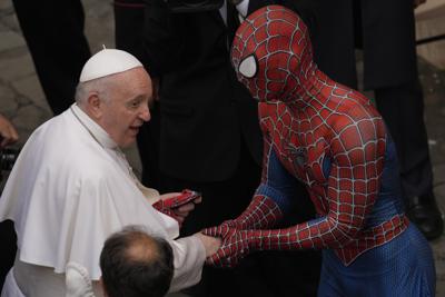 El Hombre Araña regala su máscara al papa Francisco al final de la audiencia general semanal en el patio de San Dámaso, Vaticano, miércoles 23 de junio de 2021. El hombre disfrazado ayuda a niños enfermos en los hospitales. (AP Foto/Andrew Medichini)