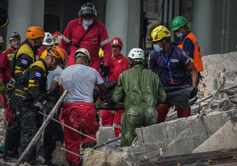 Equipos de rescate recuperan un cuerpo en el lugar de una explosión mortal que destruyó el Hotel Saratoga de cinco estrellas, en La Habana, Cuba, el viernes 6 de mayo de 2022. Una poderosa explosión aparentemente causada por una fuga de gas natural mató al menos a 18 personas, entre ellas una mujer embarazada y un niño, e hirió a decenas el viernes cuando voló las paredes exteriores del hotel de lujo en el corazón de la capital de Cuba.  (Foto AP/Ramón Espinosa)