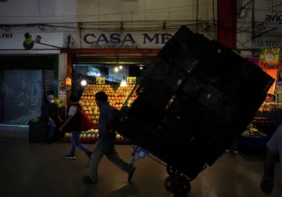 ARCHIVO - Un porteador traslada cajas de mercadería en la Central de Abastos, el mercado más grande y más completo de alimentos y bienes, en Ciudad de México, el 3 de agosto de 2022. Los presidentes de 11 países de Latinoamérica y el Caribe se comprometieron el miércoles 5 de abril de 2023, en una reunión virtual y privada, a facilitar el intercambio comercial de alimentos y materias primas para así abaratar precios y buscar la forma de abatir la inflación en la región. (AP Foto/Fernando Llano, Archivo)