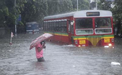 Un hombre camina por una calle inundada durante LAS intensas lluvias en Mumbai, India, el miércoles 9 de junio de 2021. (AP foto/ Rafiq Maqbool)