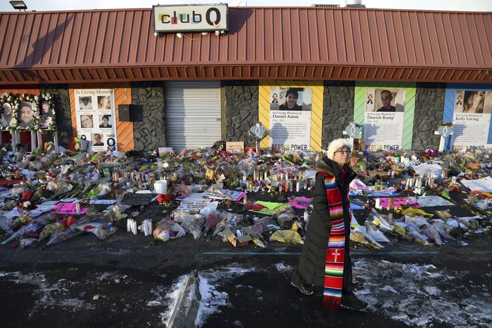 Rev. Paula Stecker of the Christ the King Lutheran Church stands in front of a memorial set up outside Club Q following last week