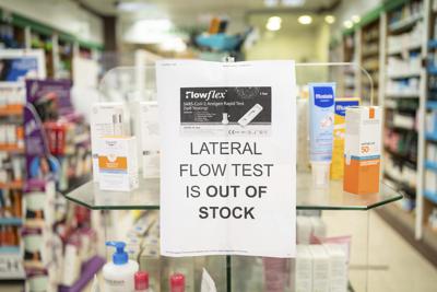 A sign saying lateral flow coronavirus tests are out of stock is displayed in a pharmacy window in London, Thursday Dec. 30, 2021. The U.K. reported a record 183,037 confirmed new coronavirus infections on Wednesday, 32% more than the previous day. While early data suggests omicron is less likely to cause serious illness than earlier variants, public health officials think the sheer number of infections could lead to a jump in hospitalizations and deaths.(Dominic Lipinski/PA via AP)