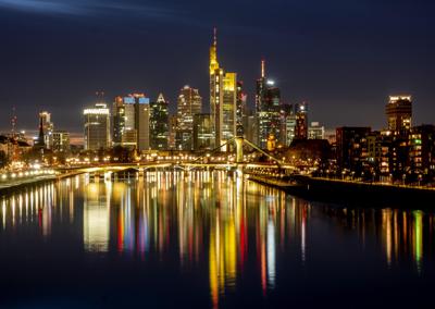 ARCHIVO - En esta foto del 14 de febrero del 2021, las luces de puentes y edificios de Fráncfort se reflejan en el río Main, en Alemania.  El Banco Central Europeo (BCE) dejó intacto su respaldo central a la economía del continente, pese a indicios de recuperación gracias a una bja en los casos del coronavirus y menos restricciones a la actividad económica en los 19 países de la zona del euro. (AP Foto/Michael Probst)