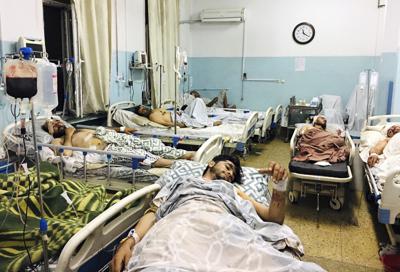 Varios afganos acostados en camas de un hospital de Kabul, Afganistán, el jueves 26 de agosto de 2021, luego de que resultaron heridos en los ataques perpetrados afuera del aeropuerto de la capital.(AP Foto/Mohammad Asif Khan)