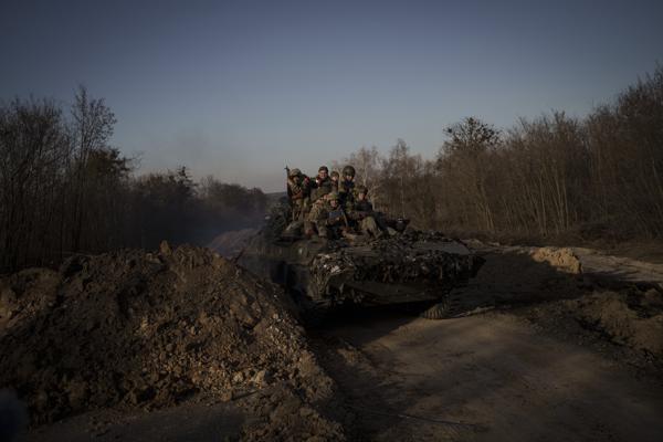 Ukrainian servicemen ride atop a tank near the town of Trostyanets, Ukraine, Monday, March 28, 2022. (AP Photo/Felipe Dana)