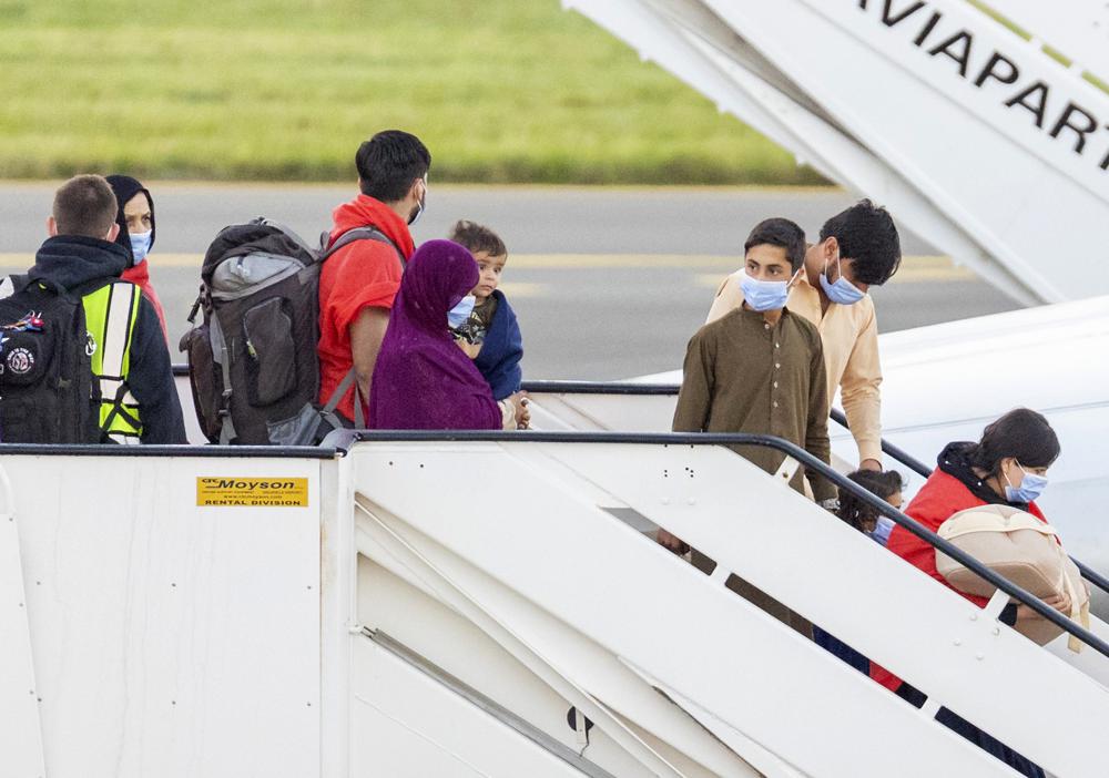 People disembark from an Air Belgium chartered plane, carrying passengers as part of an evacuation from Afghanistan, upon arrival at Melsbroek Military Airport in Melsbroek, Belgium, Friday, Aug. 27, 2021. (AP Photo/Olivier Matthys)