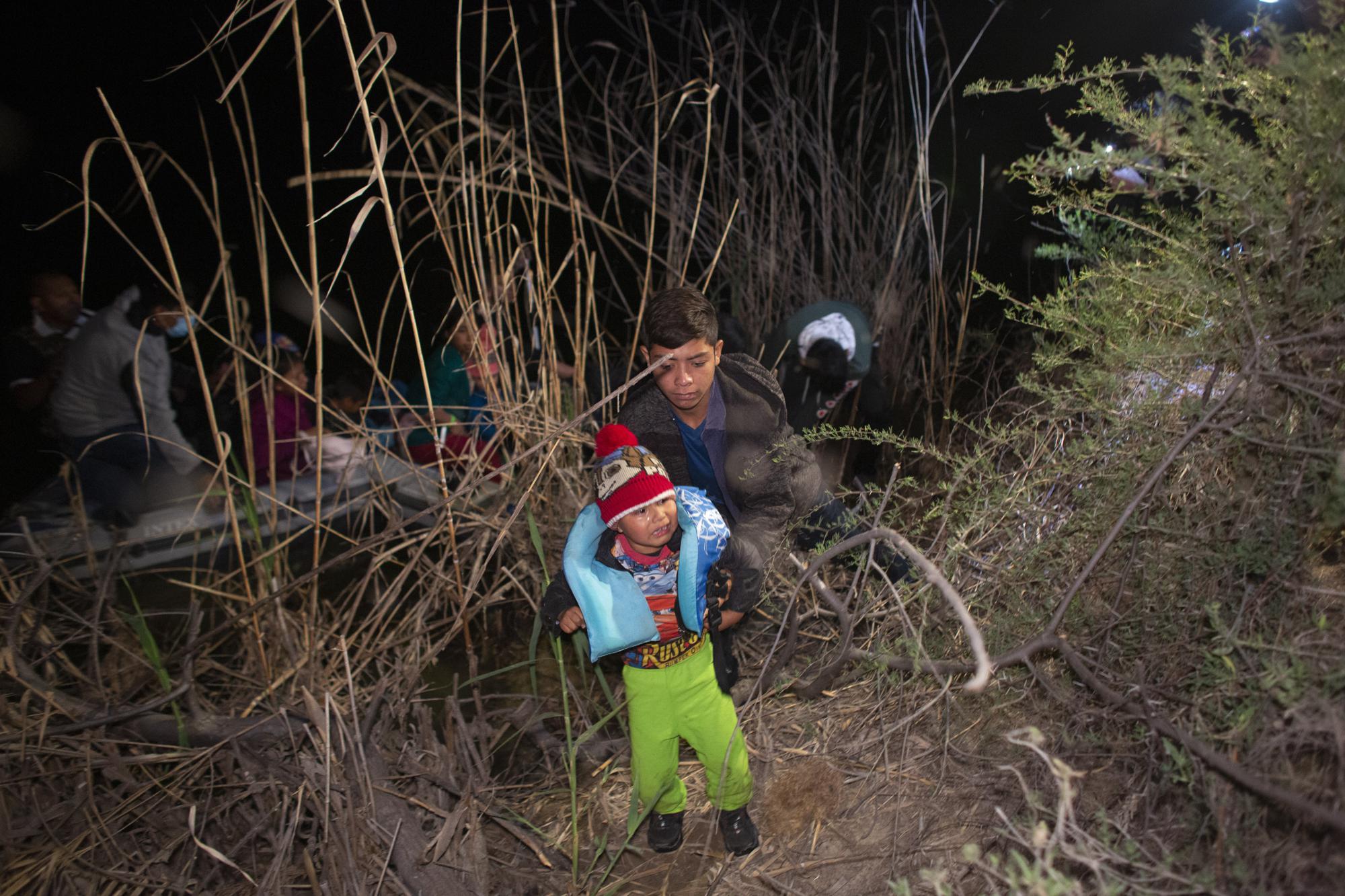 FILE - A child weeps as he is unloaded from an inflatable raft after being smuggled into the United States by crossing the Rio Grande River in Roma, Texas. March 28, 2021. Children traveling alone shattered previous highs in March, making up most of the more than 4,500 people housed in temporary tents that were designed for 250 under COVID-19 standards. (AP Photo/Dario Lopez-Mills, File)