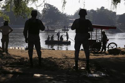 ARCHIVO - La Guardia Nacional Mexicana vigila el río Suchiate, donde los lugareños transportan carga y transportan personas entre México y Guatemala, cerca de Ciudad Hidalgo, México, el viernes 24 de enero de 2020, un lugar popular para que los migrantes centroamericanos crucen de Guatemala a México. La política migratoria mexicana está cada vez más militarizada. (AP Foto/Marco Ugarte, Archivo)