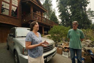 Diane Nelson y su marido, Rick, hablan sobre la llegada del incendio Caldor, que amenaza su casa en Fallen Leaf Lake, cerca del sur del Lago Tahoe, California, el martes 24 de agosto de 2021. La pareja planeaba celebrar la boda de su hija en el pintoresco lago, pero lo canceló por el humo. Pasaron dos días coordinando con los organizadores de la boda para trasladar el evento a la zona de la Bahía. (AP Foto/Rich Pedroncelli)