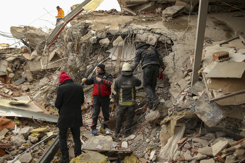 Rescue workers search for survivors on a collapsed building in Malatya, Turkey, Tuesday, Feb. 7, 2023. Search teams and aid are pouring into Turkey and Syria as rescuers working in freezing temperatures dig through the remains of buildings flattened by a magnitude 7.8 earthquake. (AP Photo/Emrah Gurel)