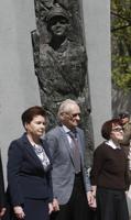 FILE - Warsaw Mayor Hanna Gronkiewicz-Waltz, left, with Andrzej Pilecki, center, and Zofia Pilecka-Obtulowicz, right, after they unveiled a monument to Capt. Witold Pilecki, in Warsaw, Poland, Saturday, May 13, 2017. The son of World War II Auschwitz death camp hero Witold Pilecki is seeking millions in compensation from Poland's government for his father's post-war arrest and his 1948 execution by the communist authorities of the time. The case opened this week before a Warsaw court. Andrzej Pilecki, aged 90, argues the compensation would be due to his father by the law that redresses communist-era wrongs. (AP Photo/Czarek Sokolowski, File)