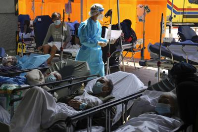 Numerosos pacientes aguardan atención en una zona especial afuera del Centro Médico Caritas en Hong Kong, el miércoles 2 de marzo de 2022, día en que registró la cifra récord de 55.353 casos de COVID-19. (AP Foto/Kin Cheung)