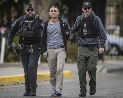 Solomon Pena, center, a Republican candidate for New Mexico House District 14, is taken into custody by Albuquerque Police officers, Monday, Jan. 16, 2023, in southwest Albuquerque, N.M. Pena was arrested in connection with a recent series of drive-by shootings targeting Democratic lawmakers in New Mexico. (Roberto E. Rosales/The Albuquerque Journal via AP)