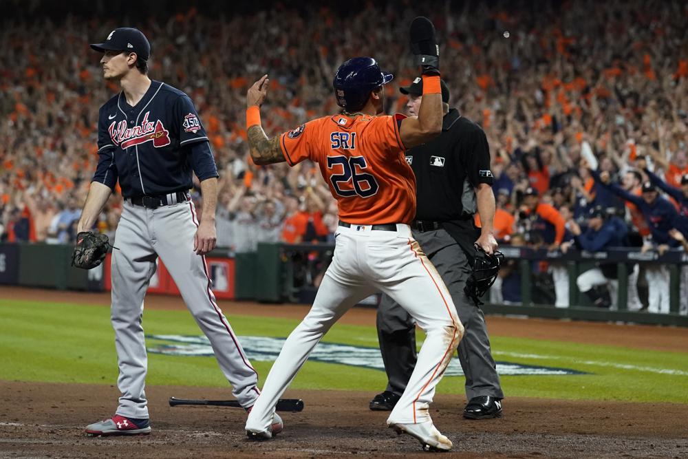 Houston Astros' Jose Siri celebrates past Atlanta Braves starting pitcher Max Fried on a throwing error during the second inning in Game 2 of baseball's World Series between the Houston Astros and the Atlanta Braves Wednesday, Oct. 27, 2021, in Houston. (AP Photo/Eric Gay)