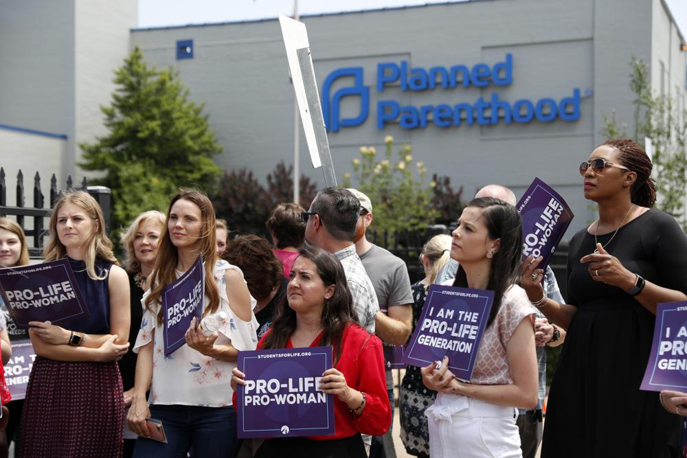 FILE - In this June 4, 2019, file photo, anti-abortion advocates gather outside the Planned Parenthood clinic in St. Louis. A federal appeals court on Tuesday, Sept. 21, 2021, will consider whether Missouri can implement a sweeping law aimed at limiting abortions. The law adopted in 2019 would ban abortions at or around the eighth week of pregnancy. It also would prohibit abortions based on a Down syndrome diagnosis. (AP Photo/Jeff Roberson, File)