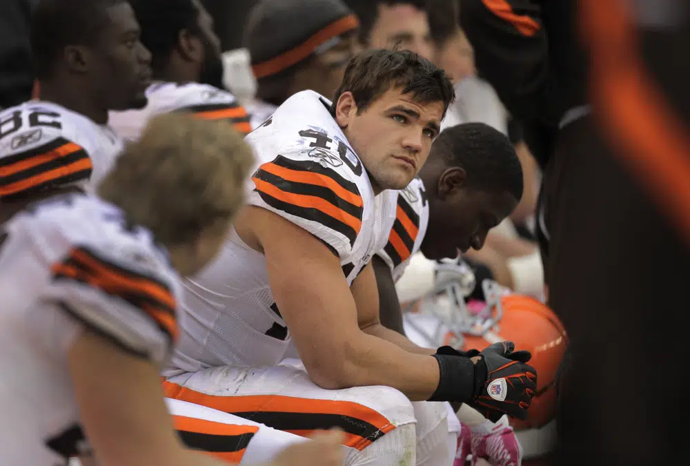 FILE - Cleveland Browns running back Peyton Hillis sits on the bench late in the team's 31-13 loss to the Tennessee Titans in an NFL football game on Oct. 2, 2011, in Cleveland. When the former running back's mother pointed to his son and niece off a Florida beach and said they were drowning, he said he didn’t think and just ran for the water. Hillis saved the children from a rip current off the coast of Pensacola in January 2023, but he said in an interview broadcast Tuesday, June 13, that the scariest moment was swimming past his 9-year-old son, Orry, to his 8-year-old niece, who was in more danger. (AP Photo/Amy Sancetta, File)