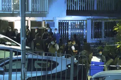 En esta imagen tomada de un video de la cadena TVB Hong Kong, agentes de la policía allanan una vivienda donde encontraron restos humanos relacionados con una modelo desaparecida, en Hong Kong, el domingo 26 de febrero de 2023. (TVB Hong Kong vía AP)