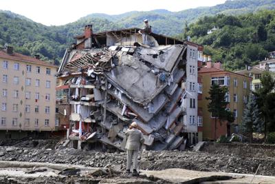 Un hombre observa el sábado 14 de agosto de 2021 un edificio de apartamentos que colapsó parcialmente tras las fuertes inundaciones y aludes en la localidad de Bozkurt, provincia de Kastamonu, en Turquía. (AP Foto)