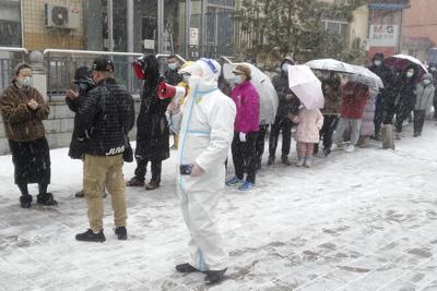 Los residentes hacen fila para la detección del coronavirus durante el confinamiento por COVID-19 en Changchun, en la provincia nororiental china de Jilin, el sábado 12 de marzo de 2022. China ordenó el viernes el confinamiento de los 9 millones de residentes de la ciudad nororiental de Changchun en medio de un nuevo aumento en los casos de COVID-19 en el área atribuido a la variante de omicron altamente contagiosa. (Chinatopix vía AP)