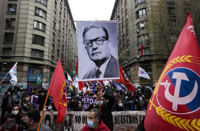 Un manifestante sostiene una fotografía del presidente chileno finado Salvador Allende durante las protestas por el 48vo aniversario del golpe militar de 1973 y su muerte subsecuente, en Santiago, Chile, el sábado 11 de septiembre de 2021. (AP Foto/Esteban Félix)