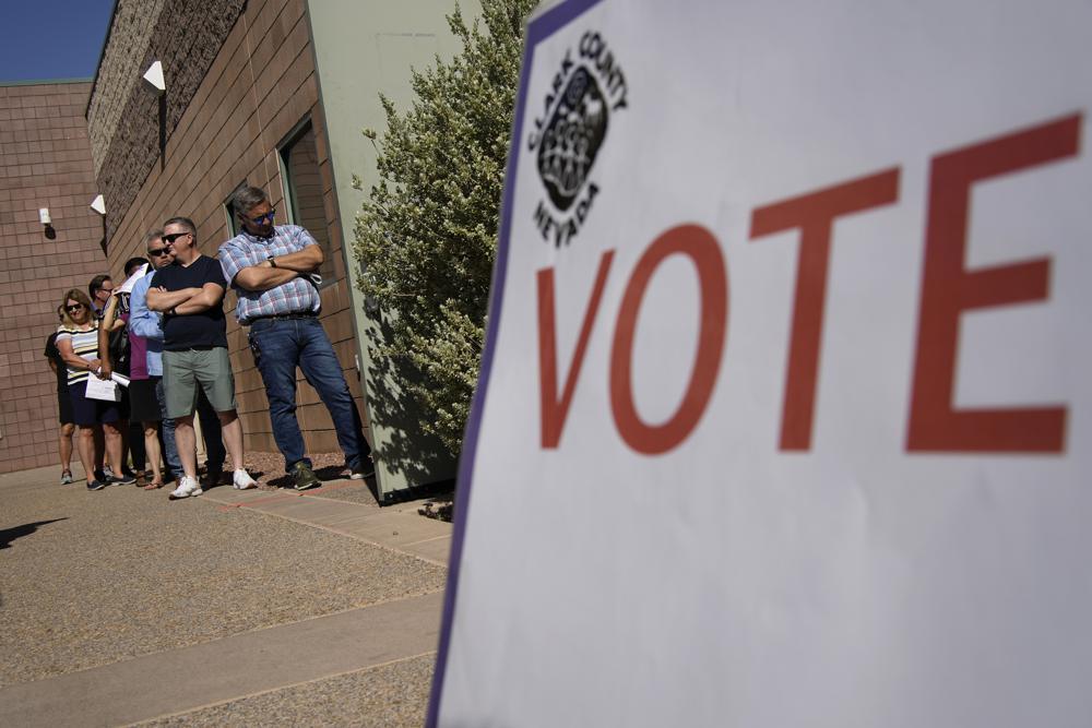 People wait in line to vote at a polling place Tuesday, June 14, 2022, in Las Vegas. (AP Photo/John Locher)
