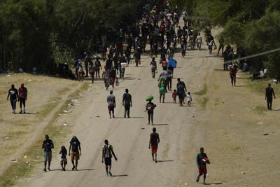 Migrantes haitianos caminan por un camino de tierra después de ingresar a Estados Unidos desde México, el viernes 17 de septiembre de 2021, en Del Rio, Texas. (AP Foto/Eric Gay)