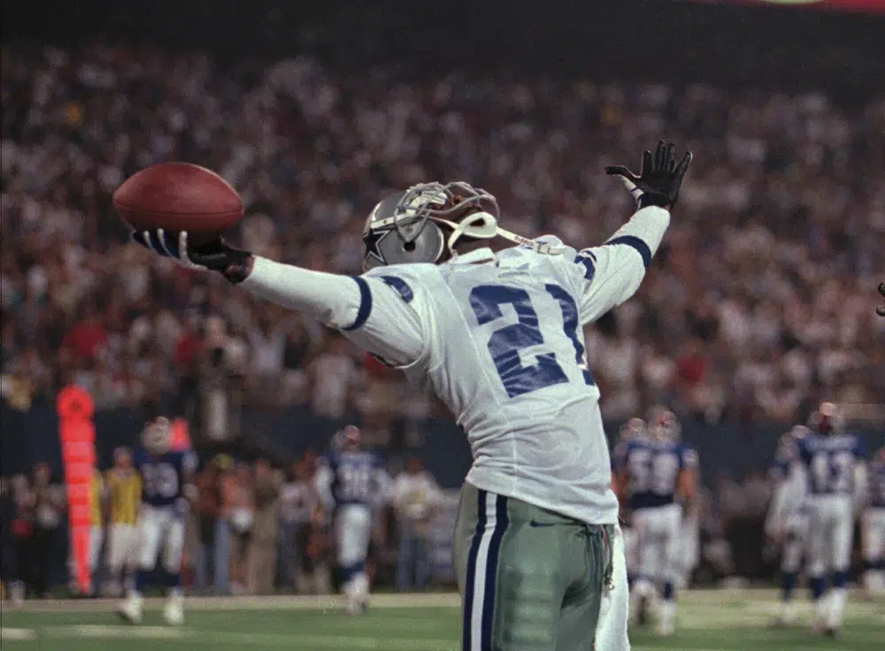 FILE - Dallas Cowboys' Deion Sanders plays to the crowd after his 59-yard punt return for a touchdown in the second quarter against the New York Giants Monday, Sept. 21, 1998, at Giants Stadium in East Rutherford, N.J. (AP Photo/John Greilick, File)