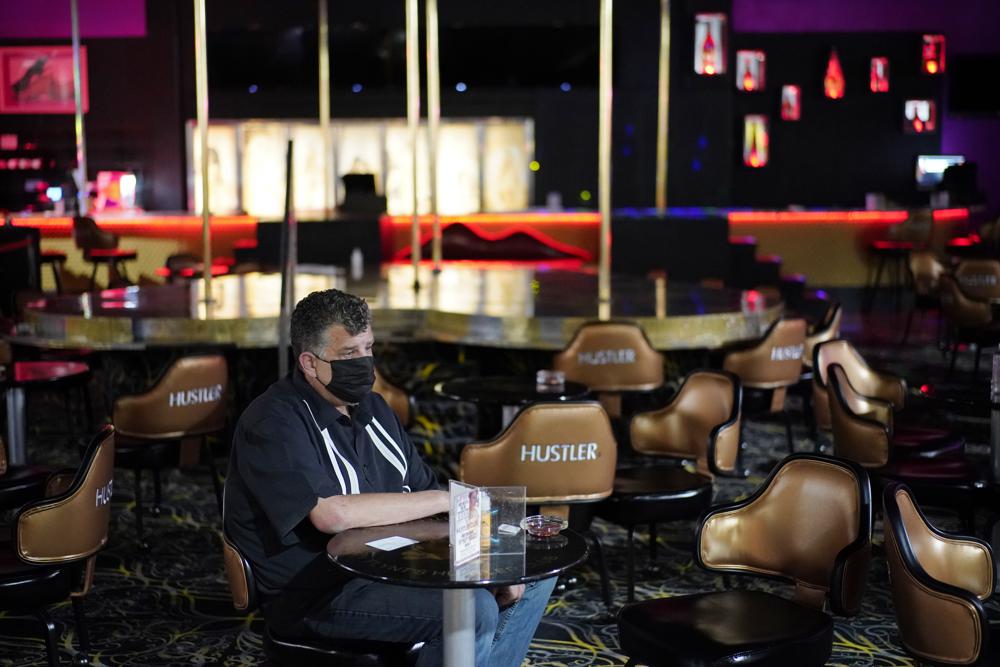 Jeff Cantrell waits at Larry Flint's Hustler Club strip club after getting his second dose of coronavirus vaccine Friday, May 21, 2021, in Las Vegas. Las Vegas officials held a pop-up vaccine clinic at the strip club (AP Photo/John Locher)