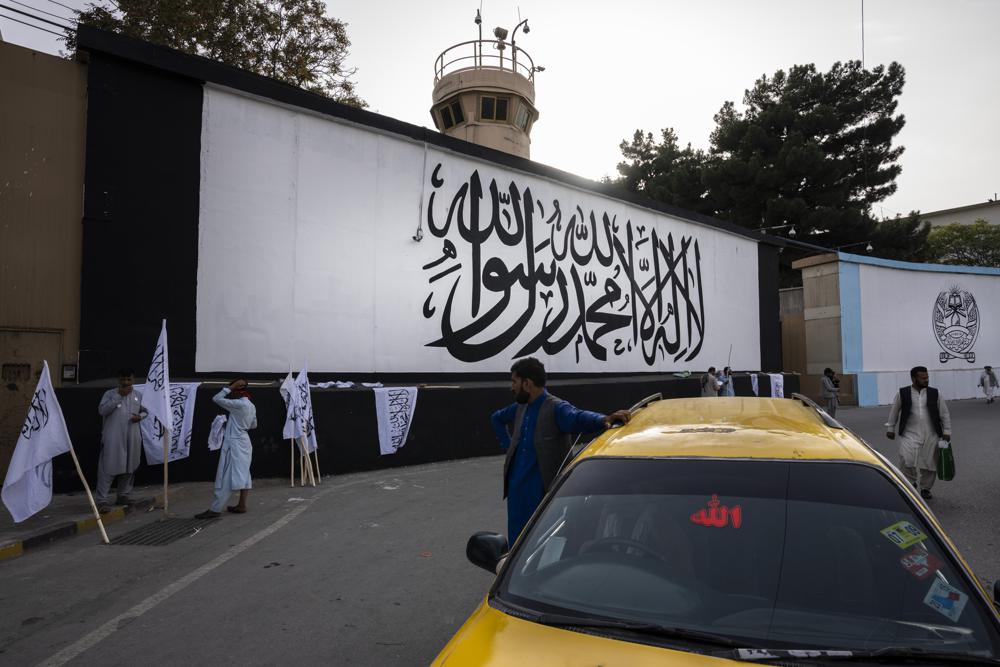 Bendera ikonik Taliban dilukis di dinding luar kompleks kedutaan Amerika di Kabul, Afghanistan, Sabtu, 11 September 2021. (AP Photo/Bernat Armangue)