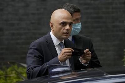 ARCHIVO - En esta fotografía del miércoles 30 de junio de 2021, el recién nombrado secretario de Salud británico Sajid Javid mira a fotógrafos mientras se coloca una mascarilla al entrar en su vehículo tras salir de la residencia oficial del primer ministro en Londres. (AP Foto/Matt Dunham, Archivo)