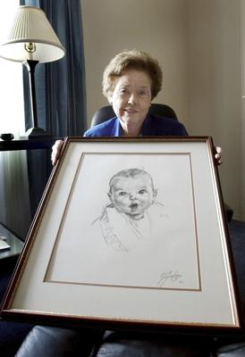 ARCHIVO - Ann Taylor Cook, posa en su casa de Tampa, Florida, la tarde del miércoles 4 de febrero de 2004, con una copia de su foto que se utiliza en todos los productos de comida para bebés de Gerber.(AP Foto/Chris O'Meara, Archivo)