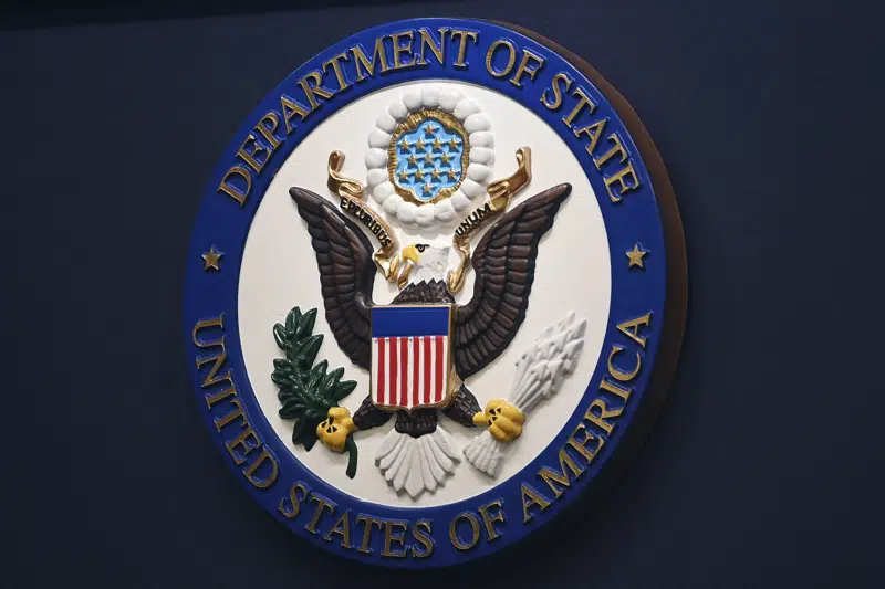 FILE - The State Department seal is seen on the briefing room lectern at the State Department in Washington, Jan. 31, 2022. Everyday Americans will be able to help refugees adjust to life in the U.S. in a program being launched by the State Department. The goal is to give private citizens a role in resettling the thousands of refugees who come to America every year. The State Department is calling the new program the Welcome Corps.(Mandel Ngan, Pool via AP, File)