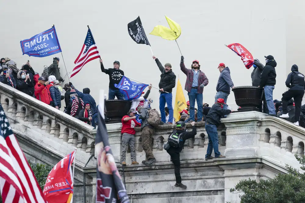 FILE - Rioters wave flags on the West Front of the U.S. Capitol in Washington on Jan. 6, 2021. Federal prosecutors are employing an unusual strategy to prove leaders of the far-right Proud Boys extremist group orchestrated a violent plot to keep President Joe Biden out of the White House, even though some of the defendants didn't carry out the violence themselves. AP Photo/Jose Luis Magana, File)