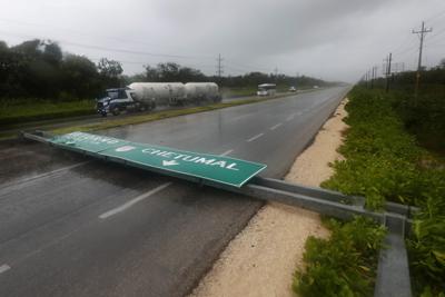 Un cartel derribado por los vientos del huracán Grace cruza una autopista en Tulum, estado de Quintana Roo, México 19 de agosto de 2021. Grace perdió fuerza, pero se pronostica que volverá a tocar tierra en México con fuerza de huracán el viernes 20. (AP Foto/Marco Ugarte)