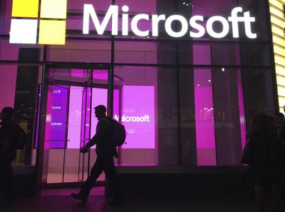ARCHIVO - En esta foto del 10 de noviembre de 2016, un hombre camina junto a las oficinas de Microsoft en Nueva York. (AP Foto/Swayne B. Hall)