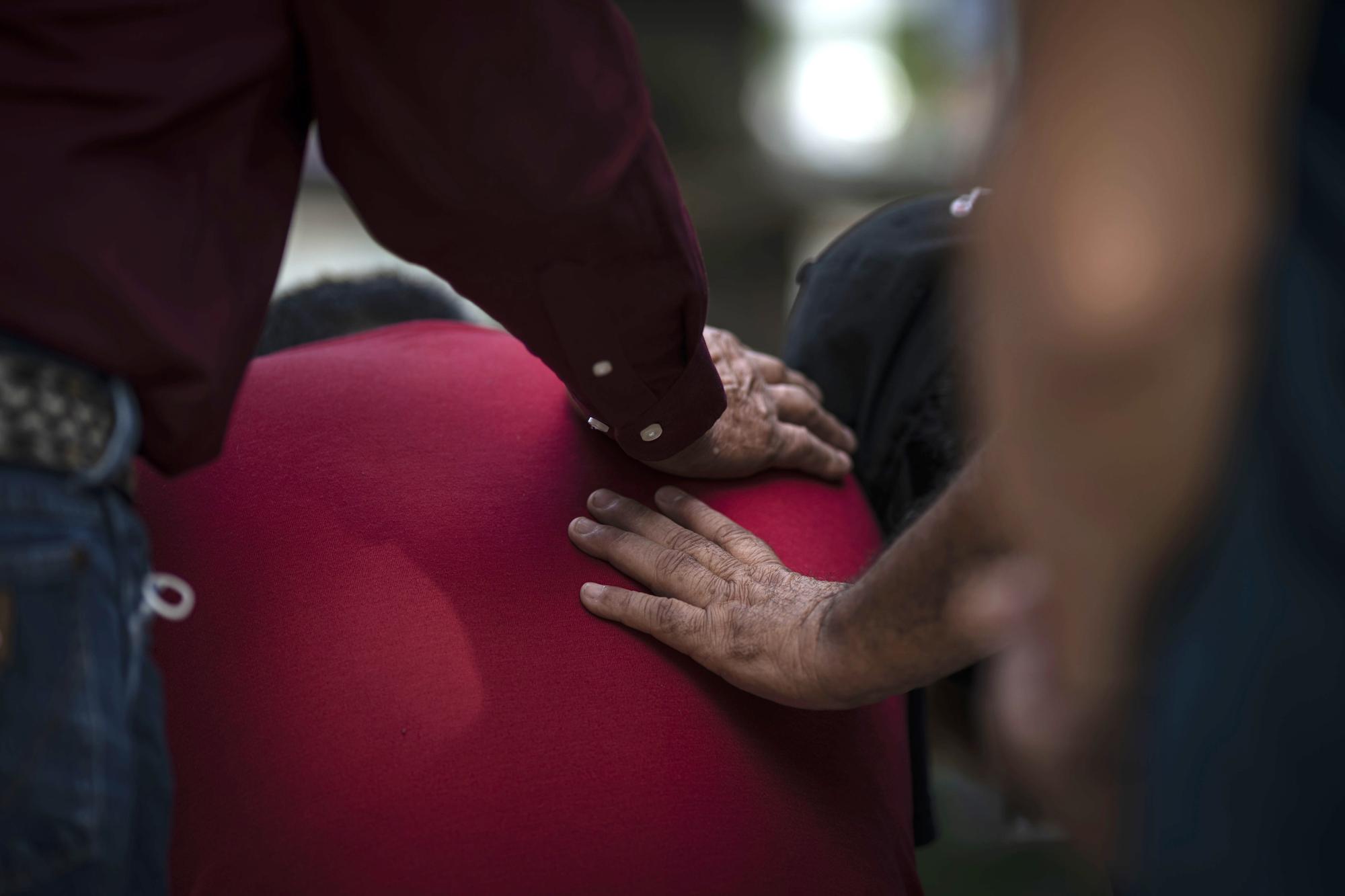 Vincent Salazar, father of Layla Salazar who was killed in the mass shooting at Robb Elementary School is comforted as he weeps at a memorial site, on Friday, May 27, 2022, in Uvalde, Texas. In a town as small as Uvalde, even those who didn't lose their own child lost someone. Some say now that closeness is both their blessing and their curse: they can lean on each other to grieve. But every single one of them is grieving. (AP Photo/Wong Maye-E)