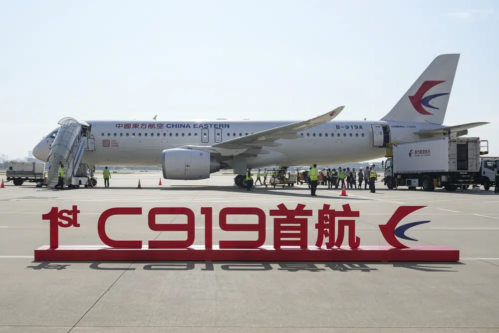 In this photo released by Xinhua News Agency, a sign which reads "1st C919 inaugural flight" is seen in front of the Chinese made passenger aircraft prepared for its first commercial flight from Shanghai on Sunday, May 28, 2023. China’s first domestically made passenger jet flew its maiden commercial flight on Sunday, as China looks to compete with companies such as Boeing and Airbus in the global aircraft market.(Ding Ting/Xinhua via AP)