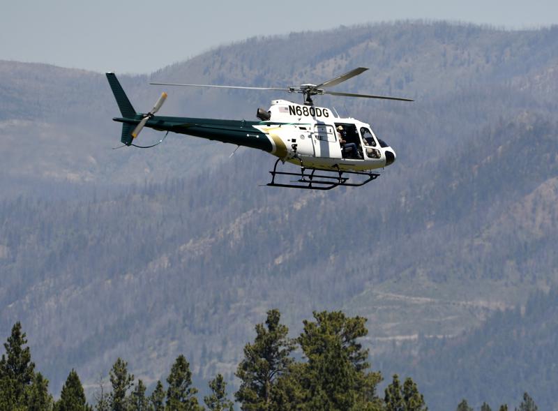 A helicopter from Montana Fish, Wildlife and Parks flies around the Ovando, Mont., area on Tuesday, July 6, 2201, in search of a bear that killed a camper early that morning. The search for the bear continued Wednesday. (Tom Bauer/The Missoulian via AP) A helicopter from Montana Fish, Wildlife and Parks flies around the Ovando, Mont., area on Tuesday, July 6, 2201, in search of a bear that killed a camper early that morning. The search for the bear continued Wednesday. (Tom Bauer/The Missoulian via AP)