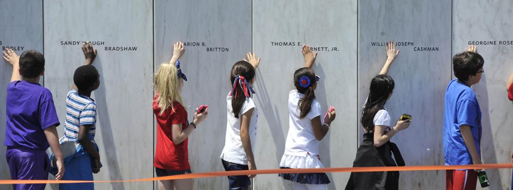 FILE - In this May 24, 2016 file photo, fourth grade students from Baldwin-Whitehall school district near Pittsburgh, touch the "wall of names" at the Flight 93 Memorial in Shanksville, Pa.,during their classroom experience. (Todd Berkey/The Tribune-Democrat via AP, File)