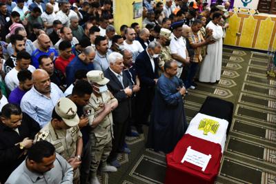 Hombres rezan frente al ataúd del militar Ahmed Mohamed Ahmed Ali, muerto en combate, durante su servicio fúnebre, el domingo 8 de mayo de 2022, en la provincia de Qalyubia, Egipto. (AP Foto/Sayed Hassan)