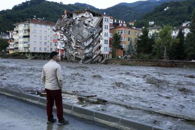 Un hombre mira las crecidas que causaron destrozos en la localidad de Bozkurt, en la provincia de Kastamonu, Turquía, el 12 de agosto de 2021. (IHA vía AP)