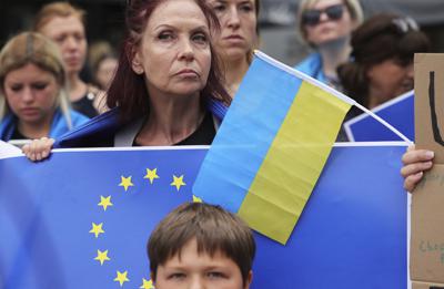 Manifestantes llevan banderas de Ucrania y la Union Europea  en una concentración en favor de Ucrania en las afueras de la UE en Bruselas el 23 de junio del 2022. (AP Foto/Olivier Matthys)